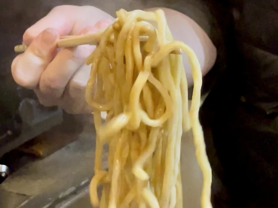 箸で持ち上げられた大量の麺