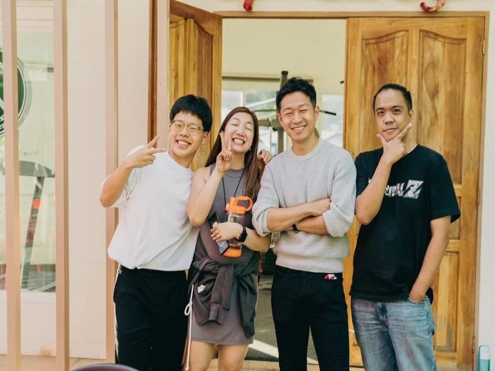 笑顔でポーズをとる4人の男女