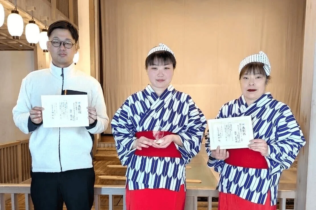 表彰状を持つ人々