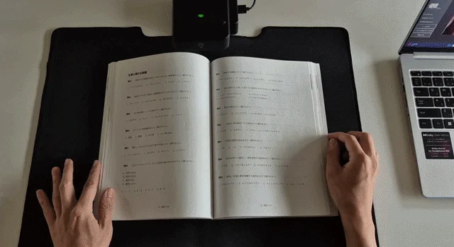 開かれた書籍をドキュメントスキャナーで読み取っている様子