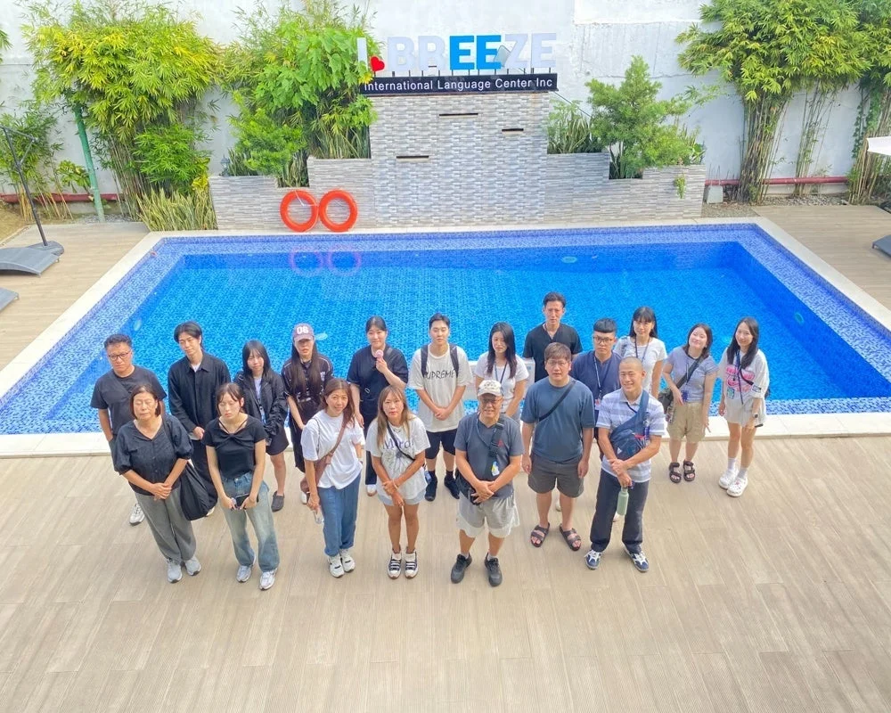 BREEZE International Language Center Incのプールサイドで、多くの生徒とスタッフらしき人々が集合写真を撮っている様子。明るい日差しの下、リラックスした雰囲気が伝わります。