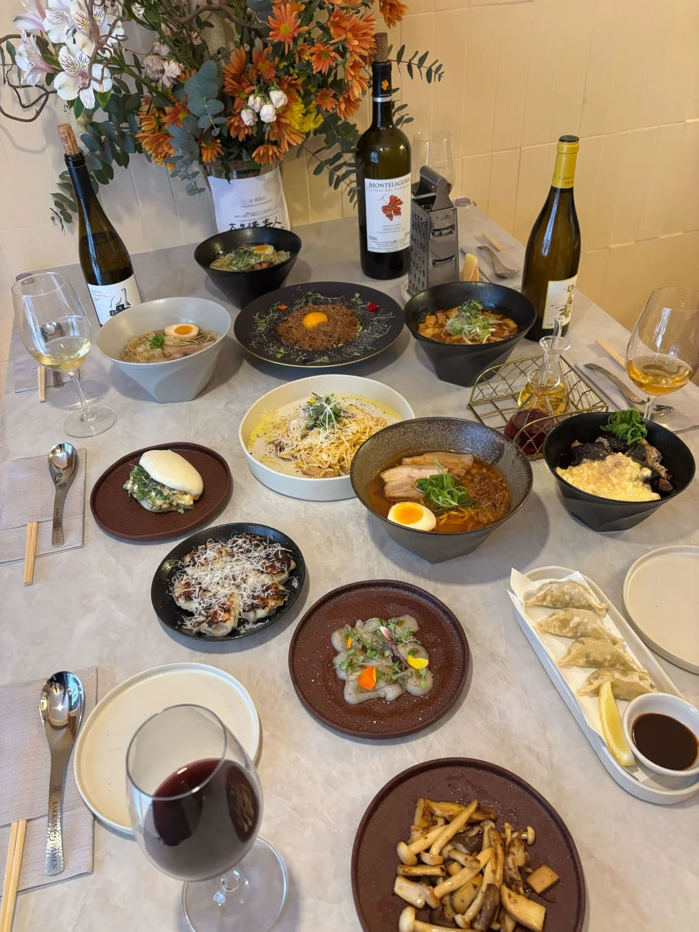 ラーメンやワインが並ぶ豪華な食卓