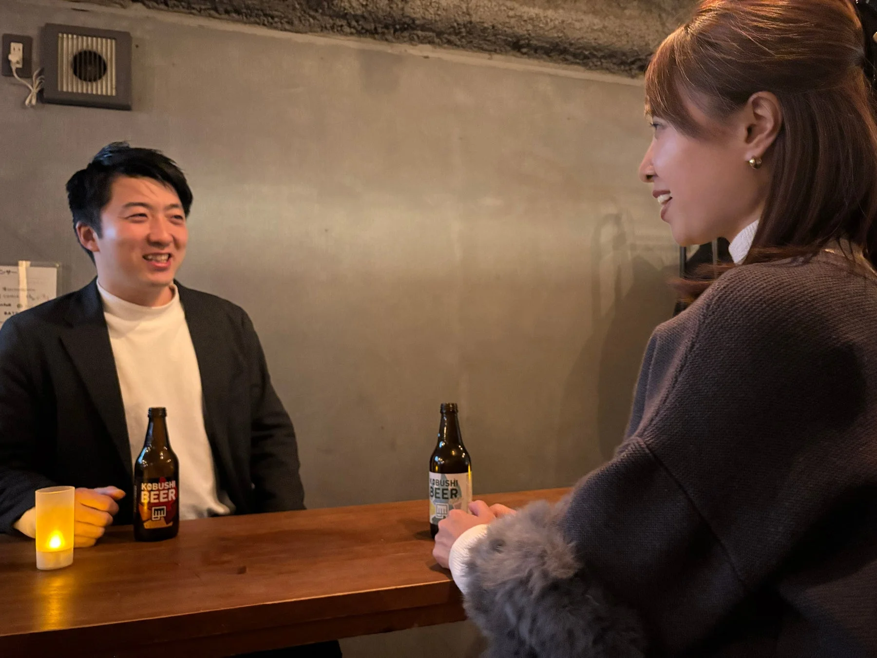 バーカウンターで男女が会話している様子