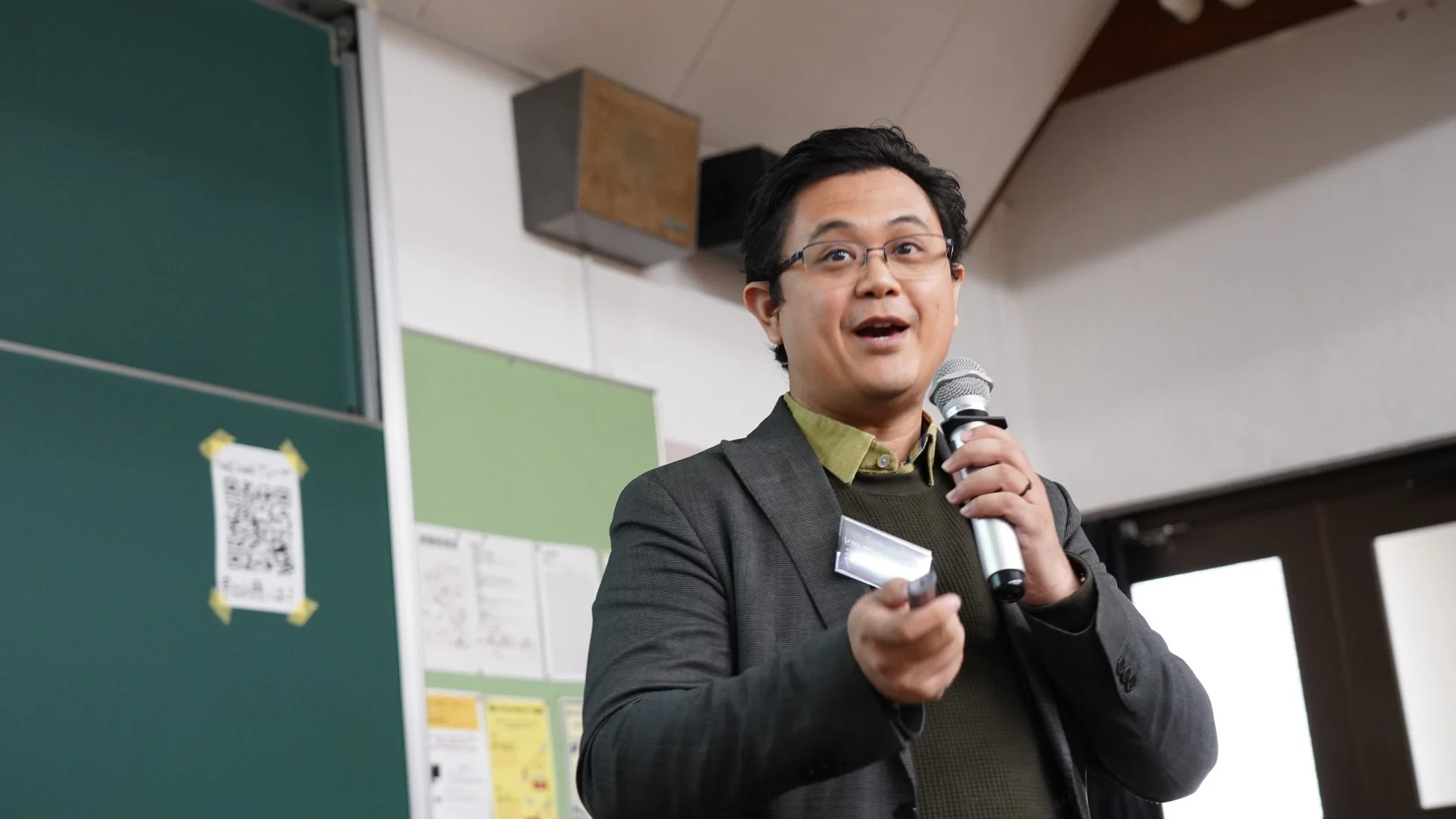 マイクを手に持ち、熱心に話す男性の姿