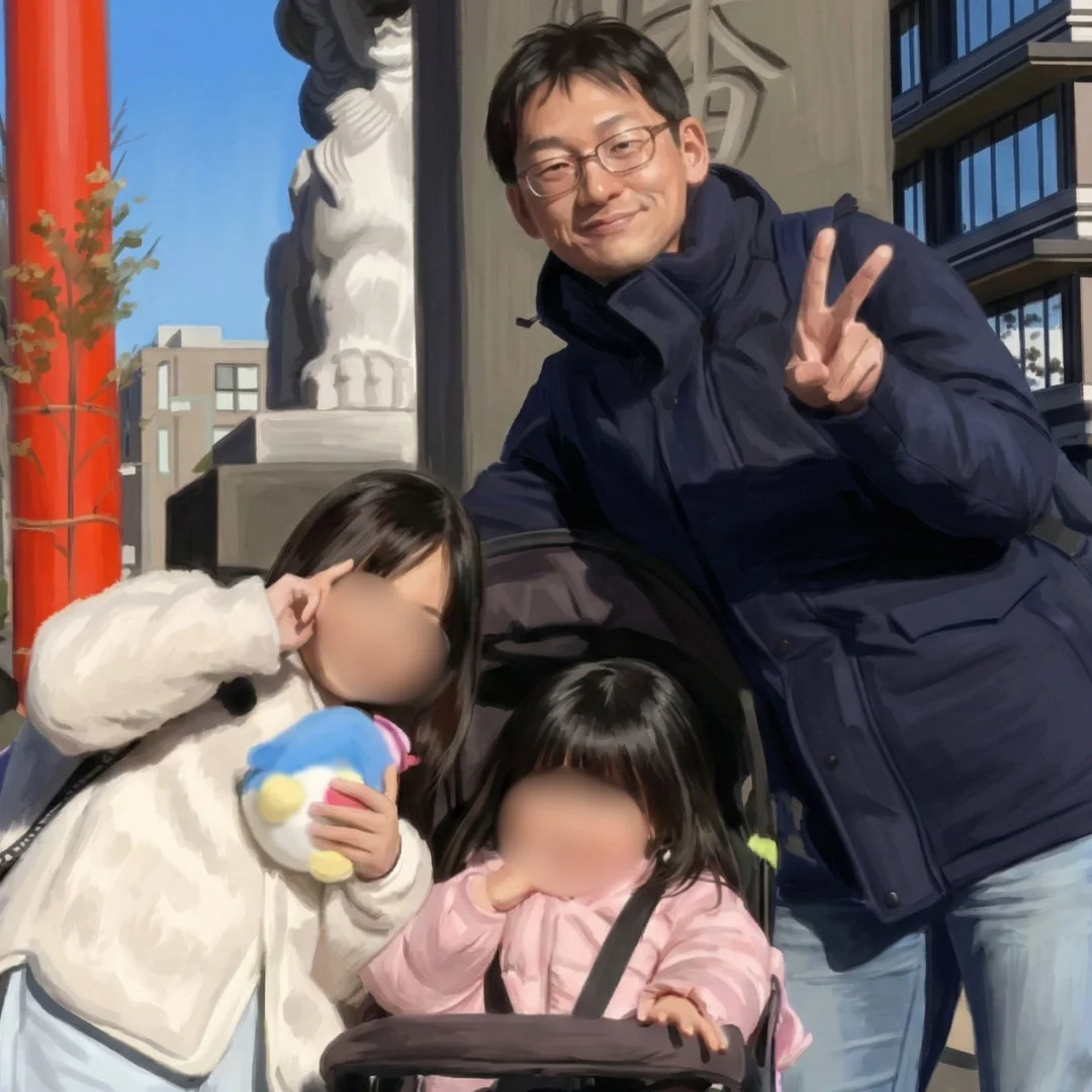 父親と2人の娘が屋外で笑顔でポーズをとっている家族写真です。父親と上の娘はピースサインをしており、下の娘はベビーカーに乗っています。背景には日本の伝統的な建物が見えます。