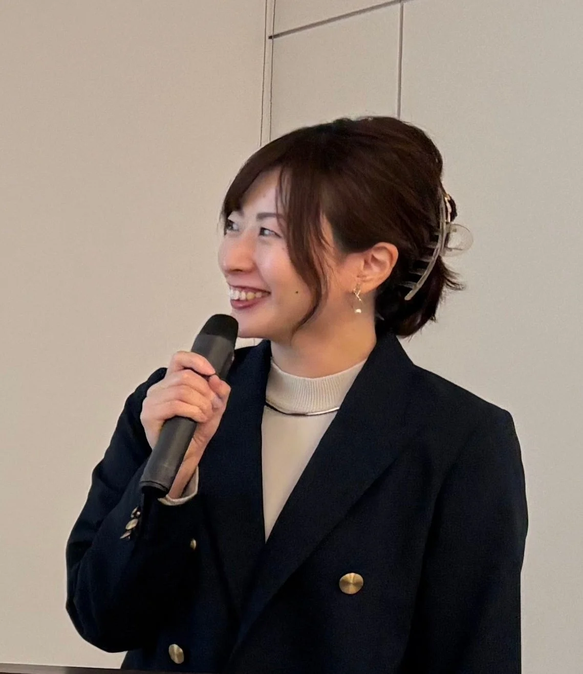 マイクを手に話す女性