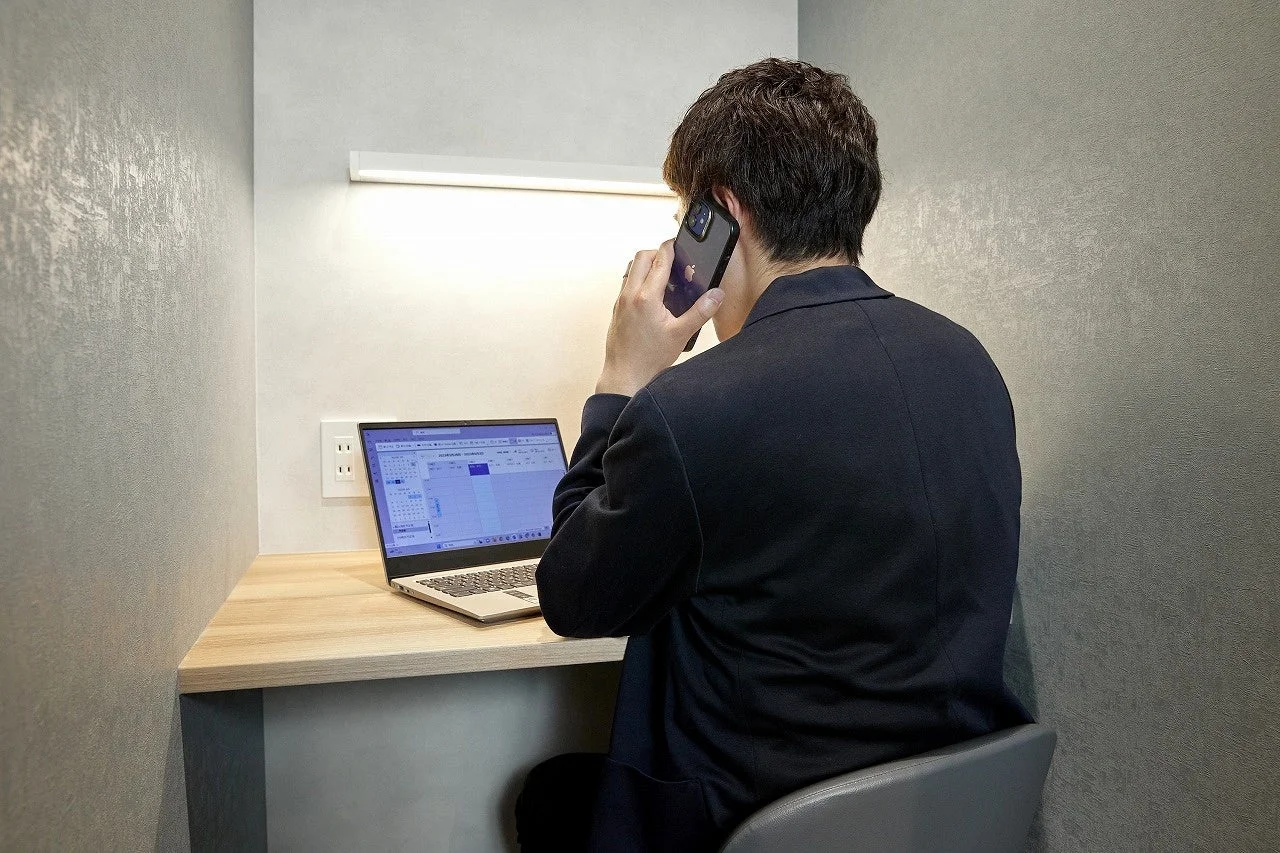 個室ブースで仕事をする男性