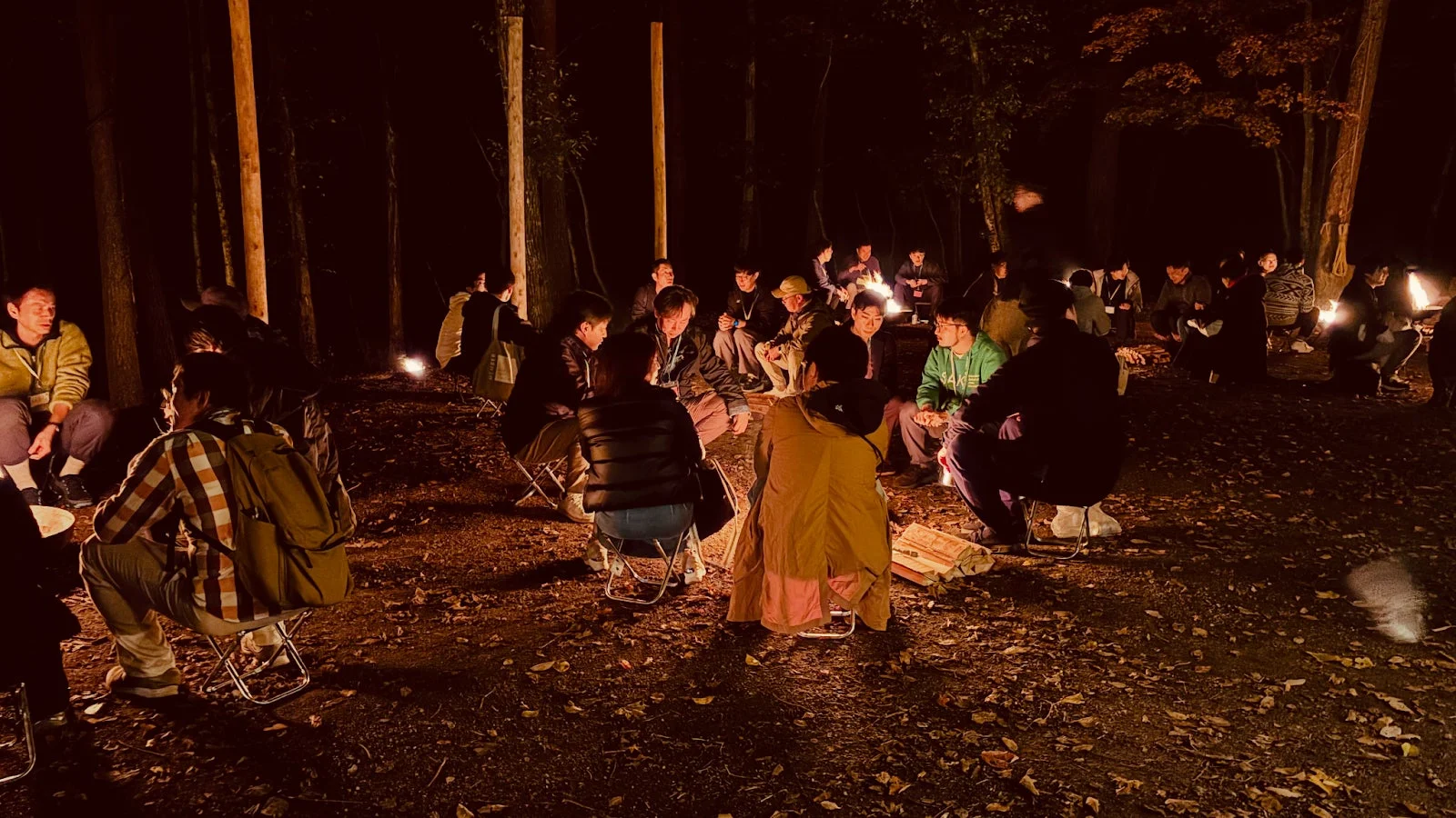 夜の森で焚き火を囲む人々