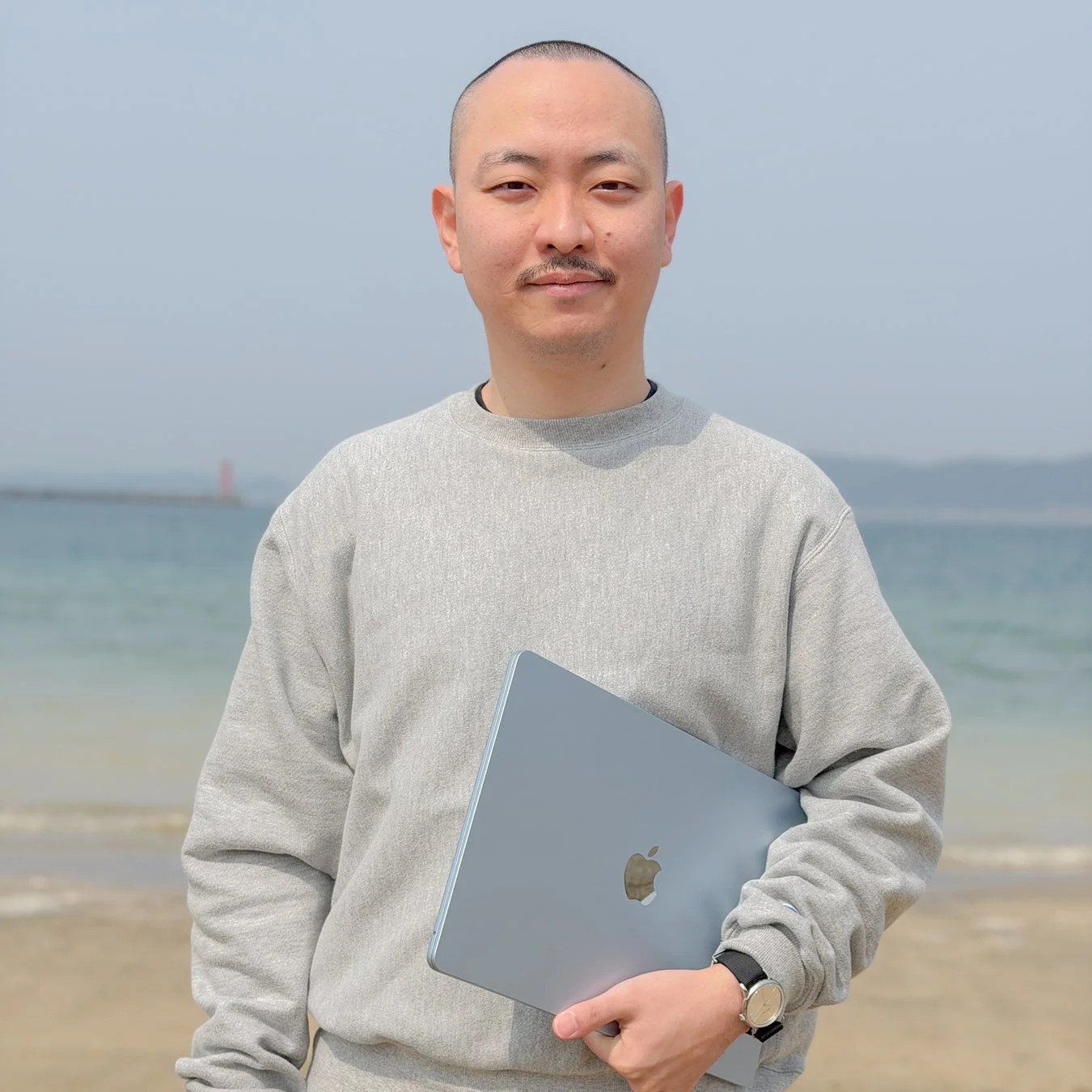 ビーチでノートパソコンを持つ男性