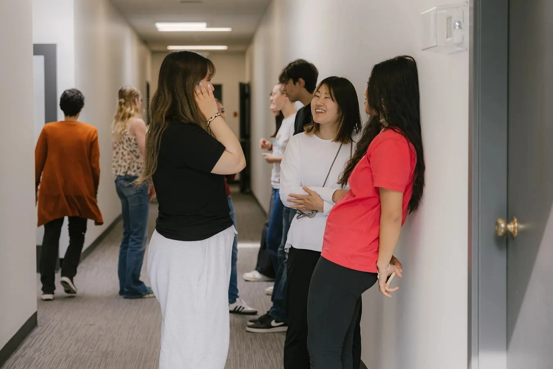 複数の人々が廊下で集まって会話を楽しんでいる様子