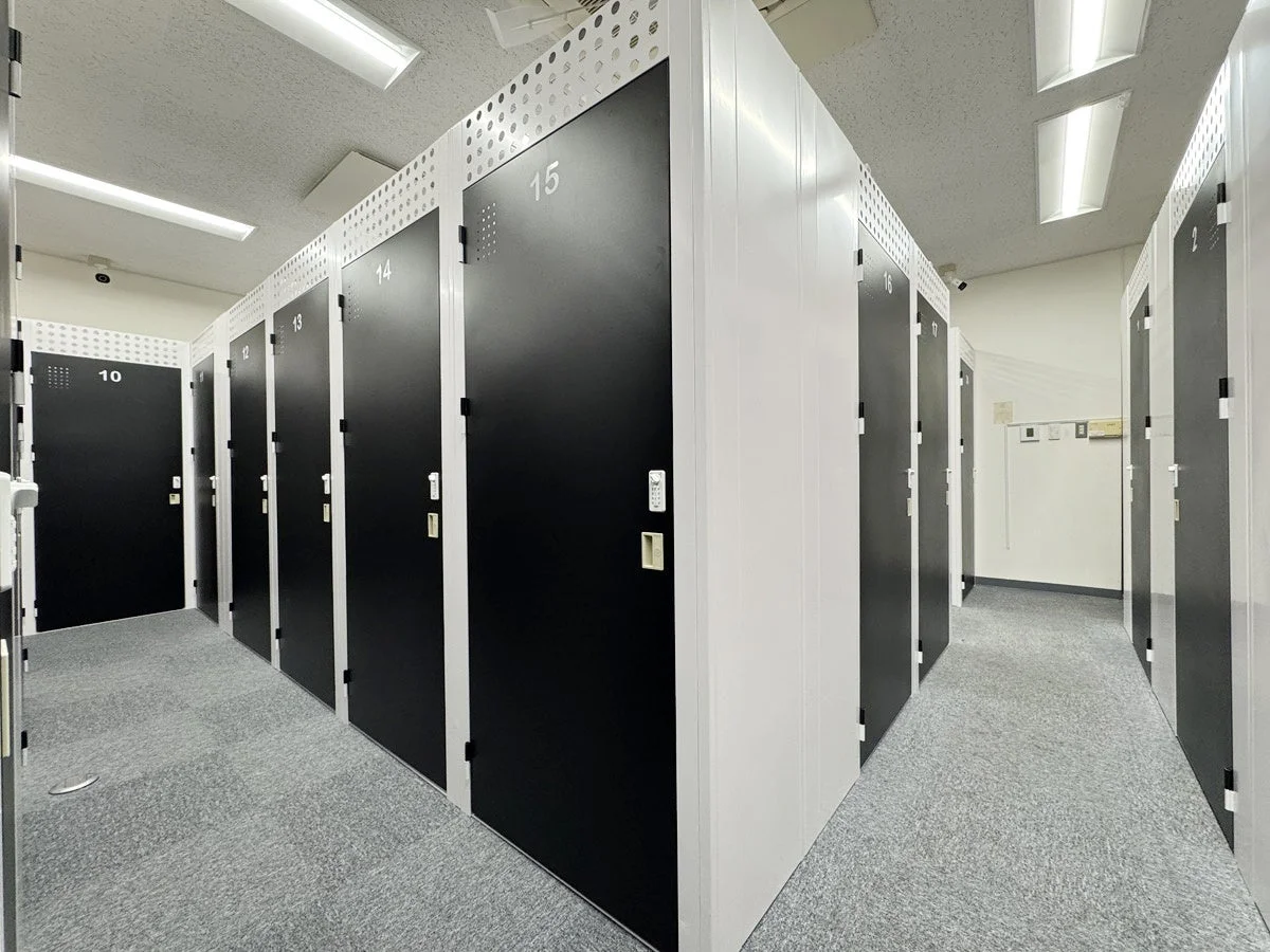 番号が振られた黒いドアが並ぶロッカーや貸倉庫のような施設内の様子