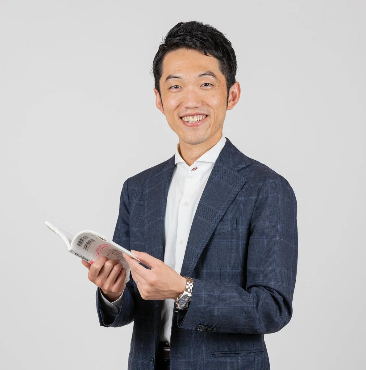 本を手に微笑む男性