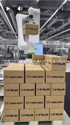 工場でロボットアームが箱を運ぶ