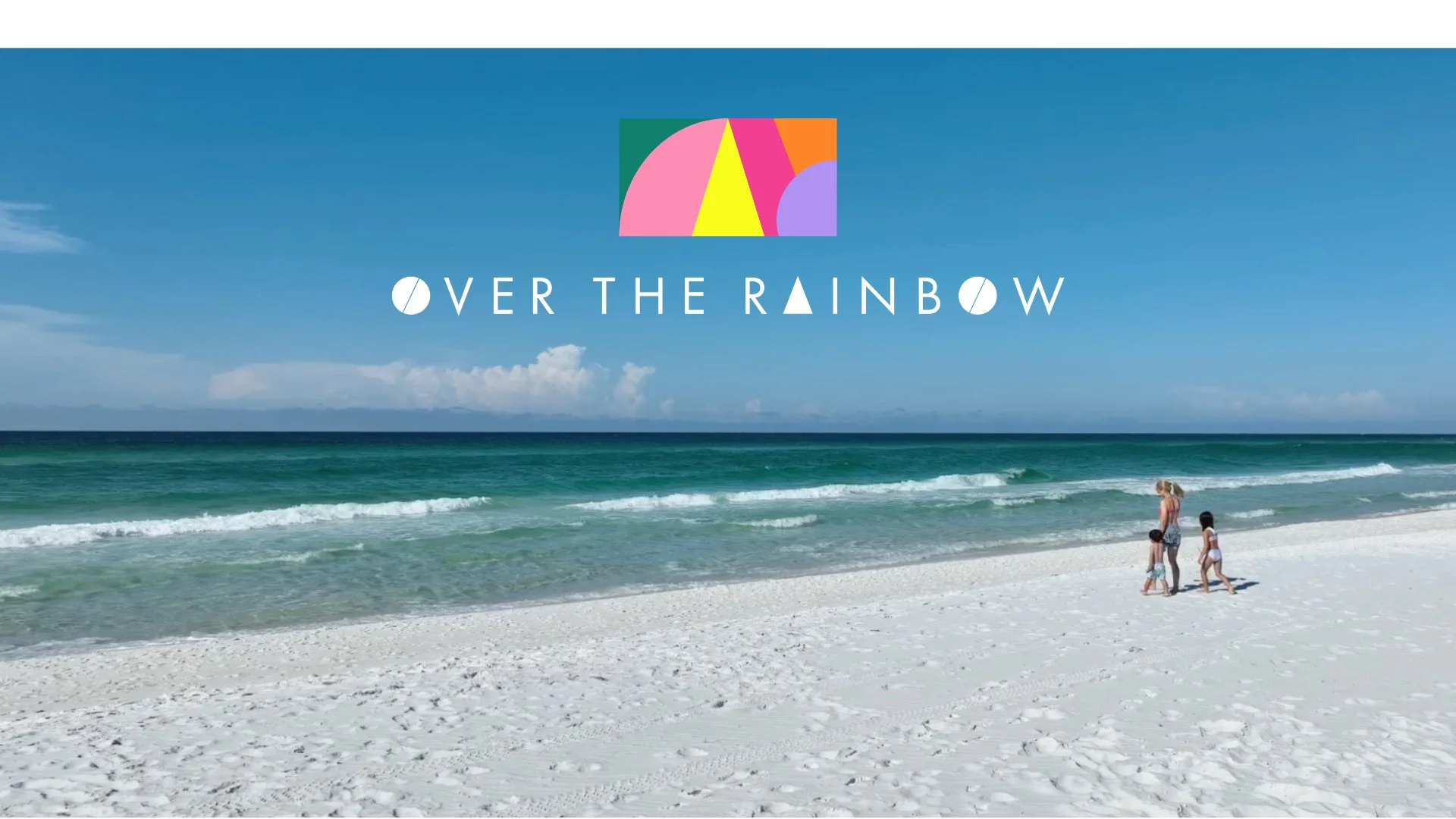 OVER THE RAINBOWのロゴとビーチを歩く家族の風景