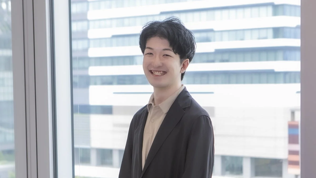 窓際で笑顔を見せる男性