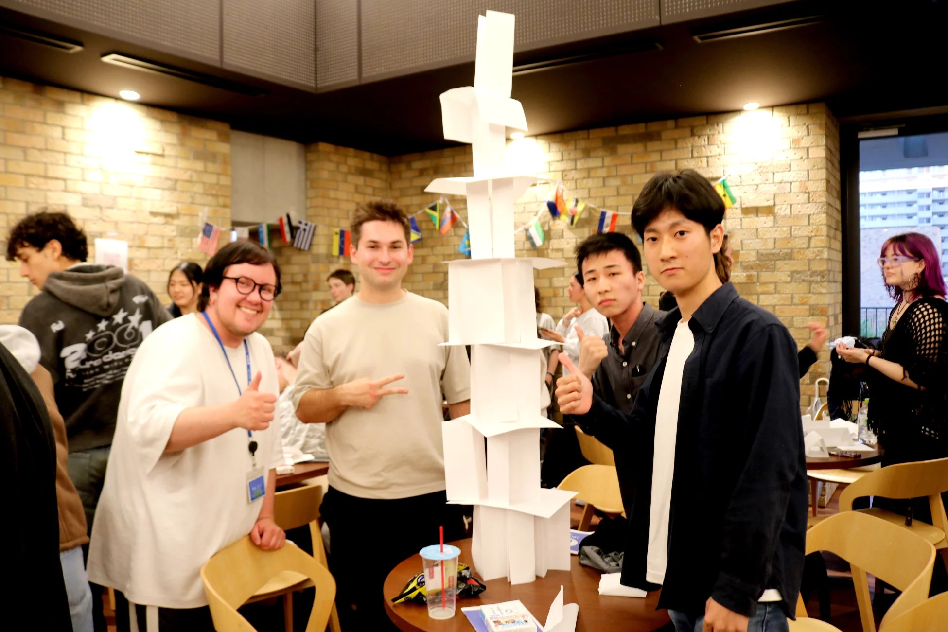 紙のタワーを囲む学生たち