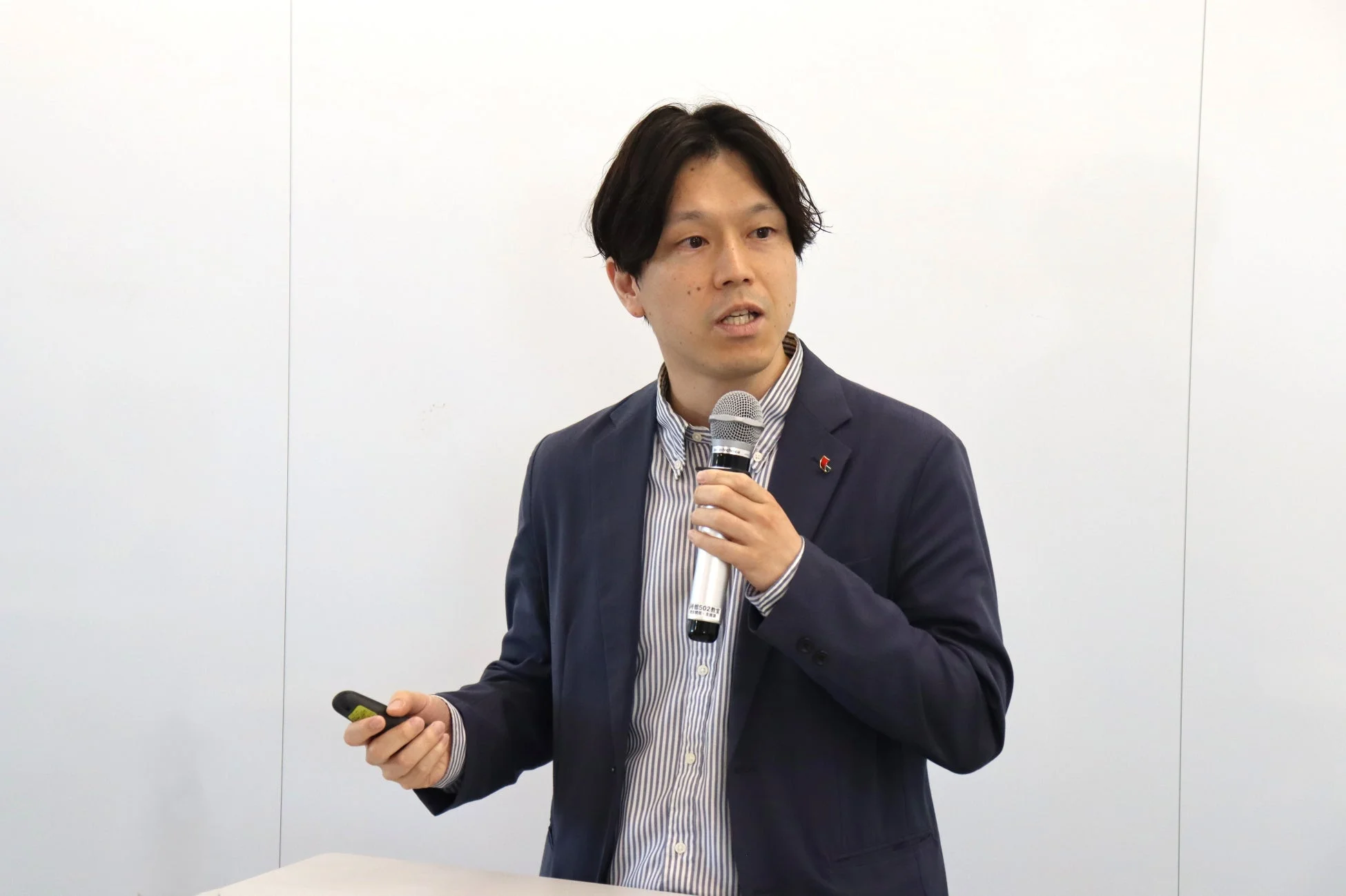 マイクとリモコンを持つ男性