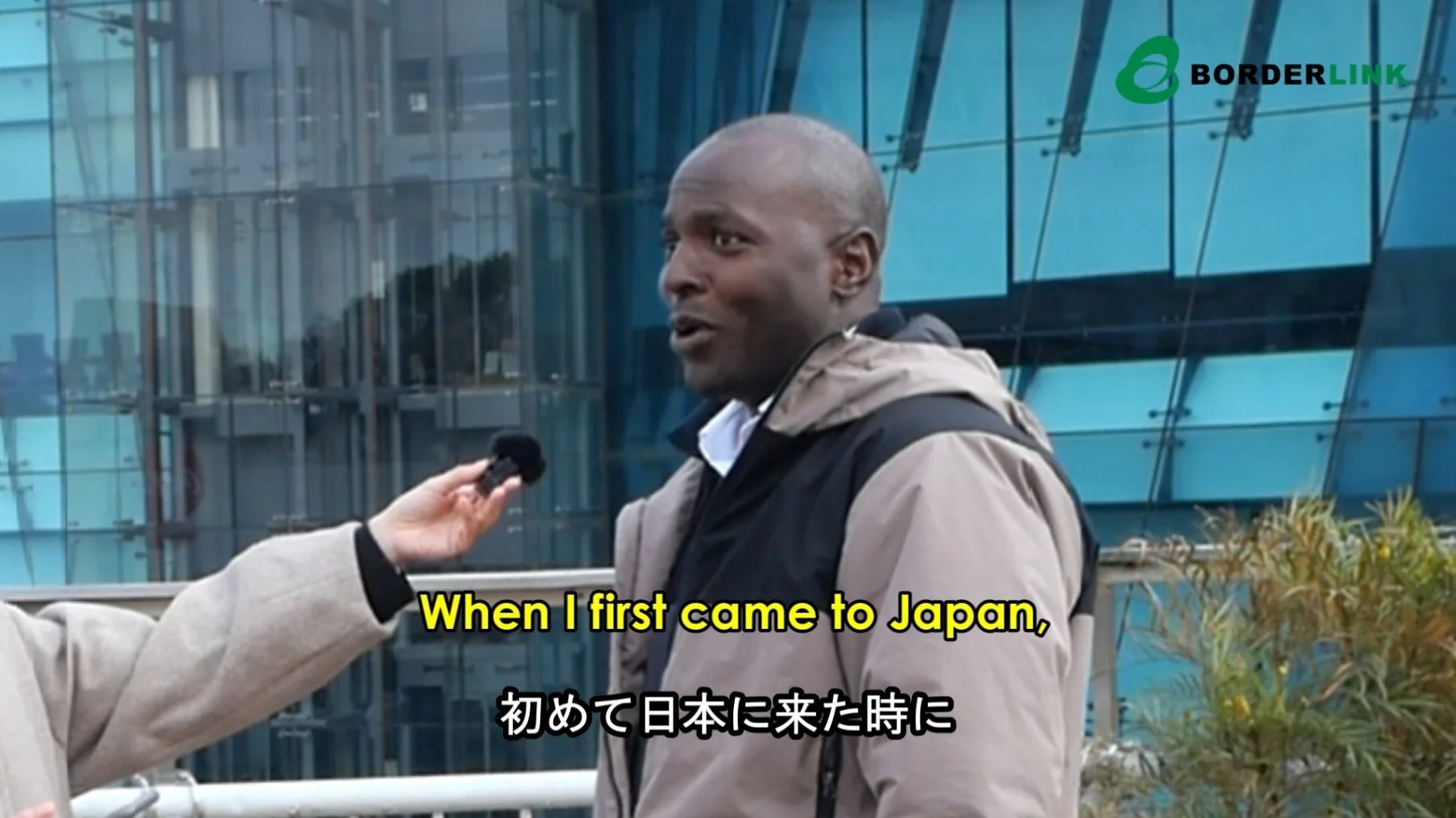 屋外でインタビューを受ける外国人男性