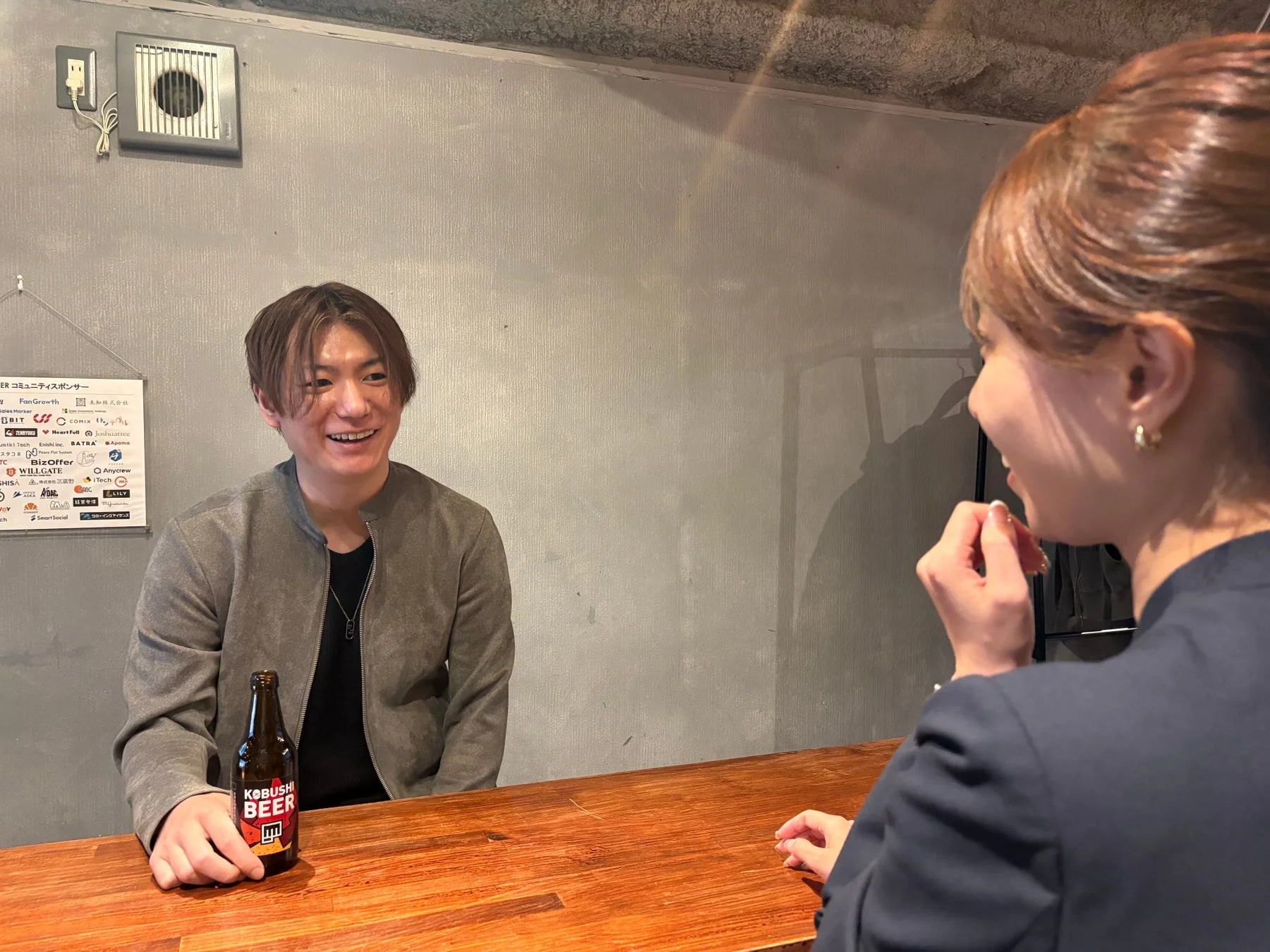 カウンターで会話している男女の画像