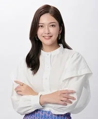 白いシャツを着て笑顔で腕を組む田中道子さん