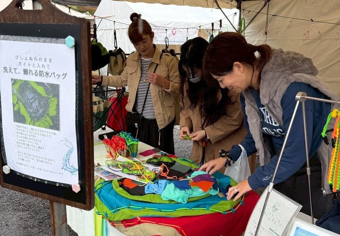 屋外イベントでizatoki防水バッグが展示されている様子