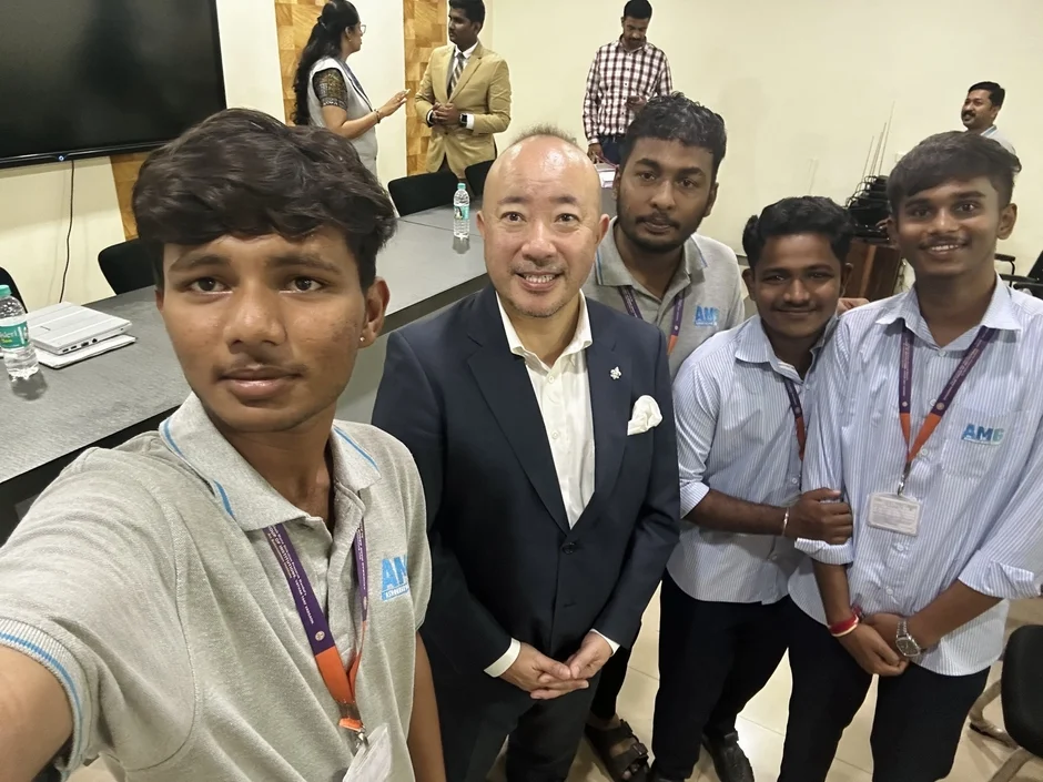 学生たちとセルフィーを撮る男性