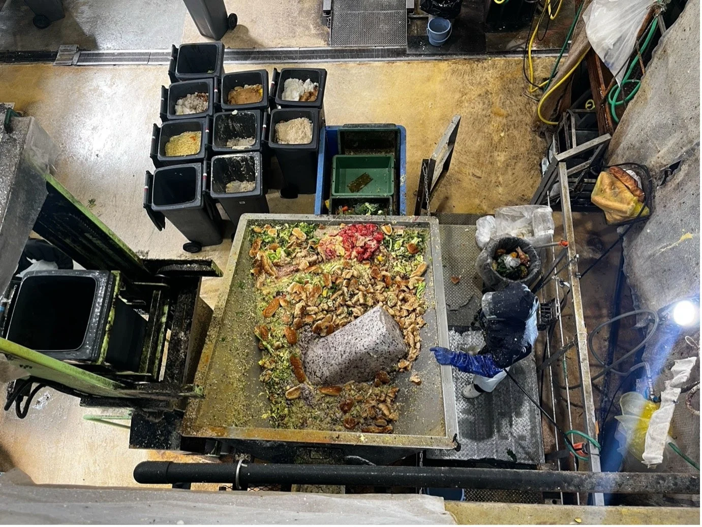 大量の食品廃棄物が集積された処理場または大規模厨房の一角を上から捉えた画像