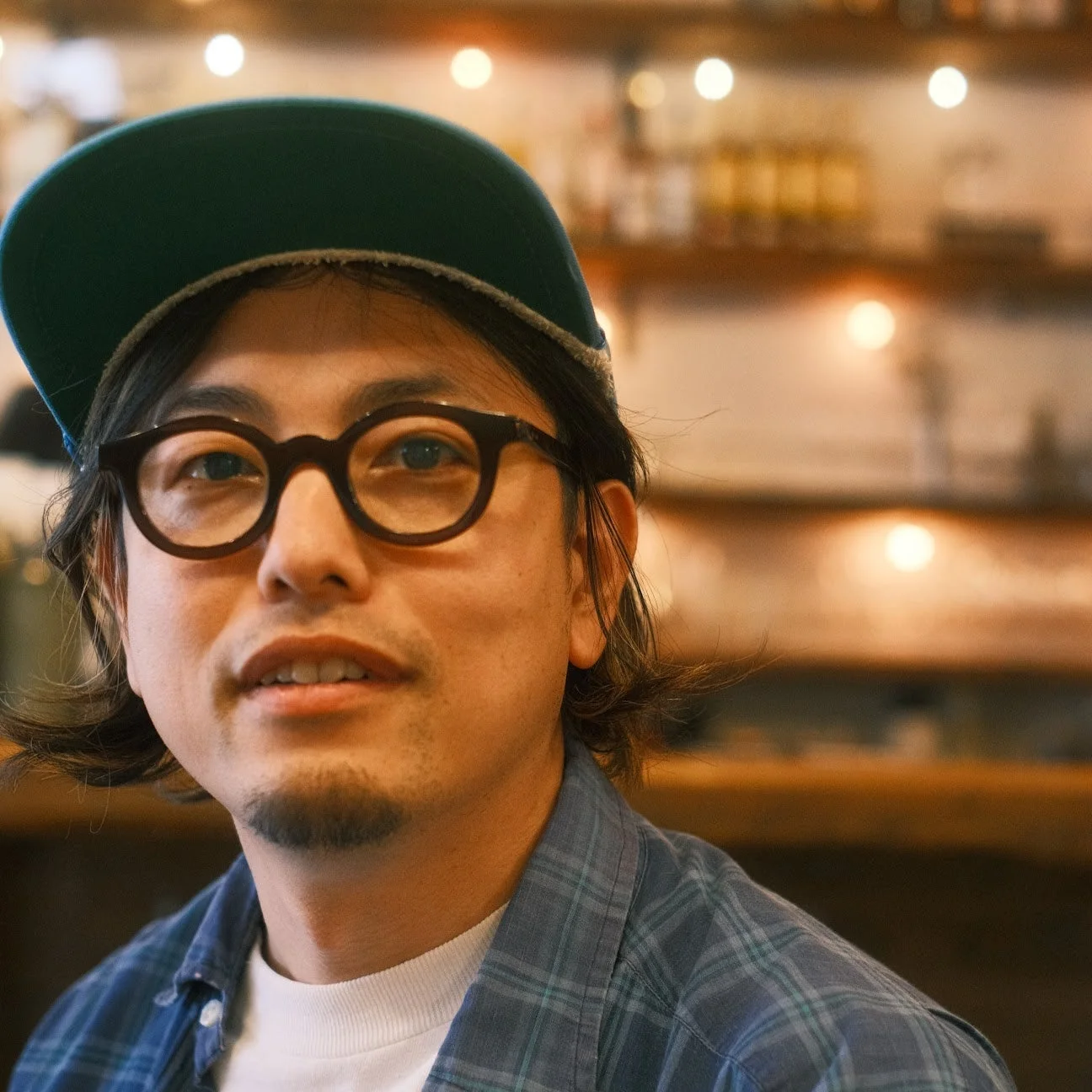 緑のキャップと丸眼鏡をかけた男性のポートレート