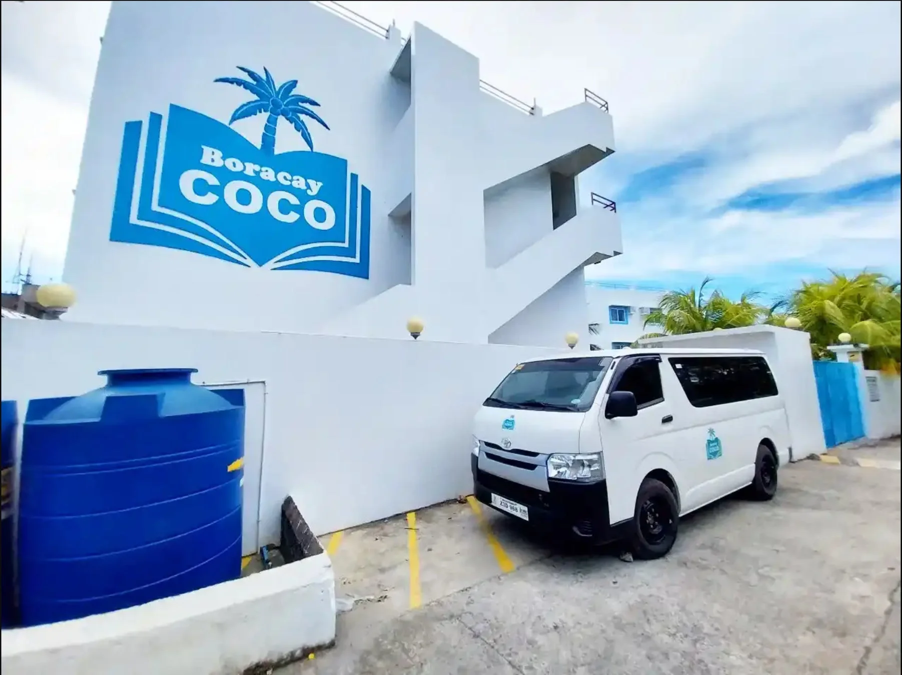 Boracay COCOのロゴが描かれた白い建物と送迎用バン